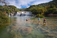 People chillig out under Skradinski buk, National Park Krka, Dalmatia, Croatia