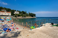 People swimming on popular beach in place Ika near town Opatija, Kvarner, Croatia